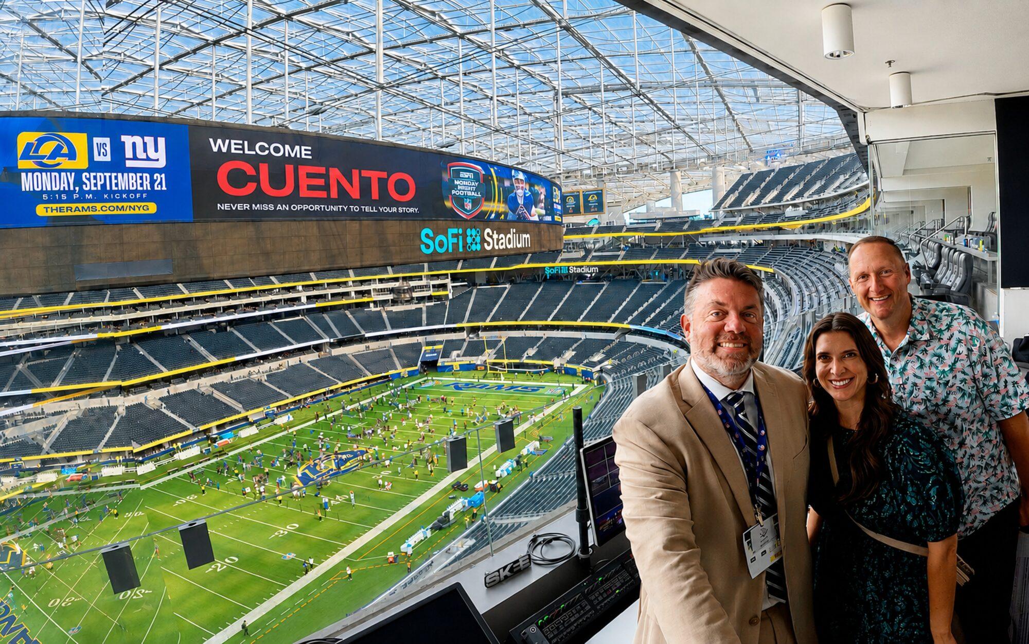 Wayne Partello and two others in a SoFi Stadium suite under a video board reading Welcome CUENTO