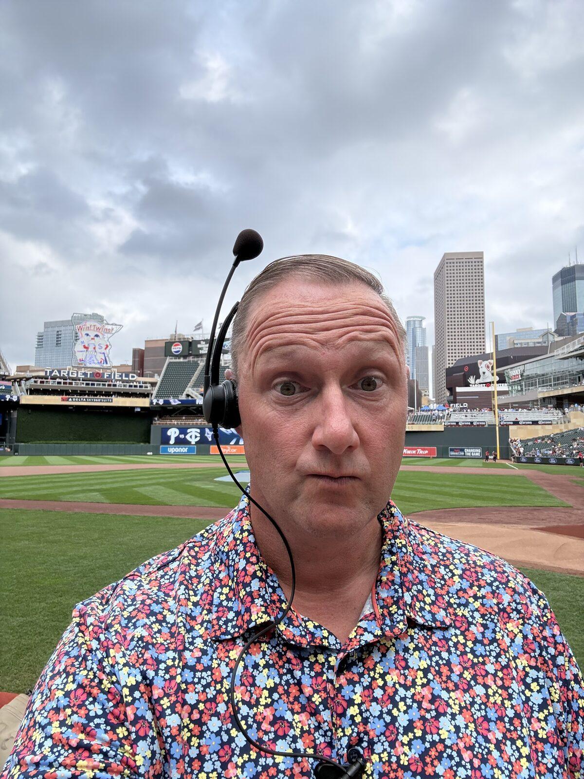 Wayne Partello wearing a headset on the field at Target Field