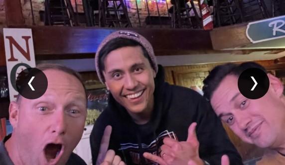 Three CUENTO teammates making a playful group photo at a bar.
