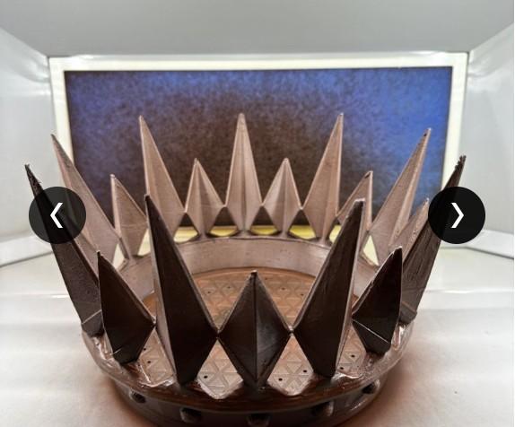 Bronze-painted 3D-printed spiked crown prop on a workbench.