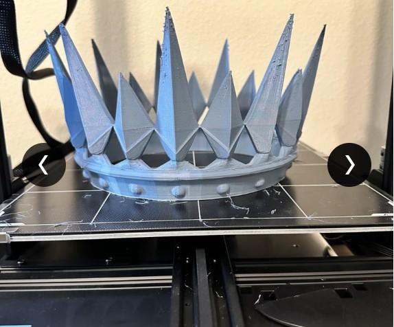 Unpainted gray 3D-printed spiked crown prop sitting on a 3D printer bed.