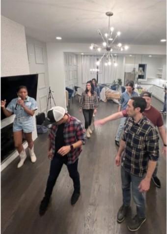 CUENTO team members dancing together in a living room during the retreat.