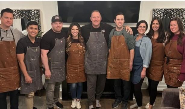 The CUENTO team poses together wearing paint-splattered aprons after the retreat activity.