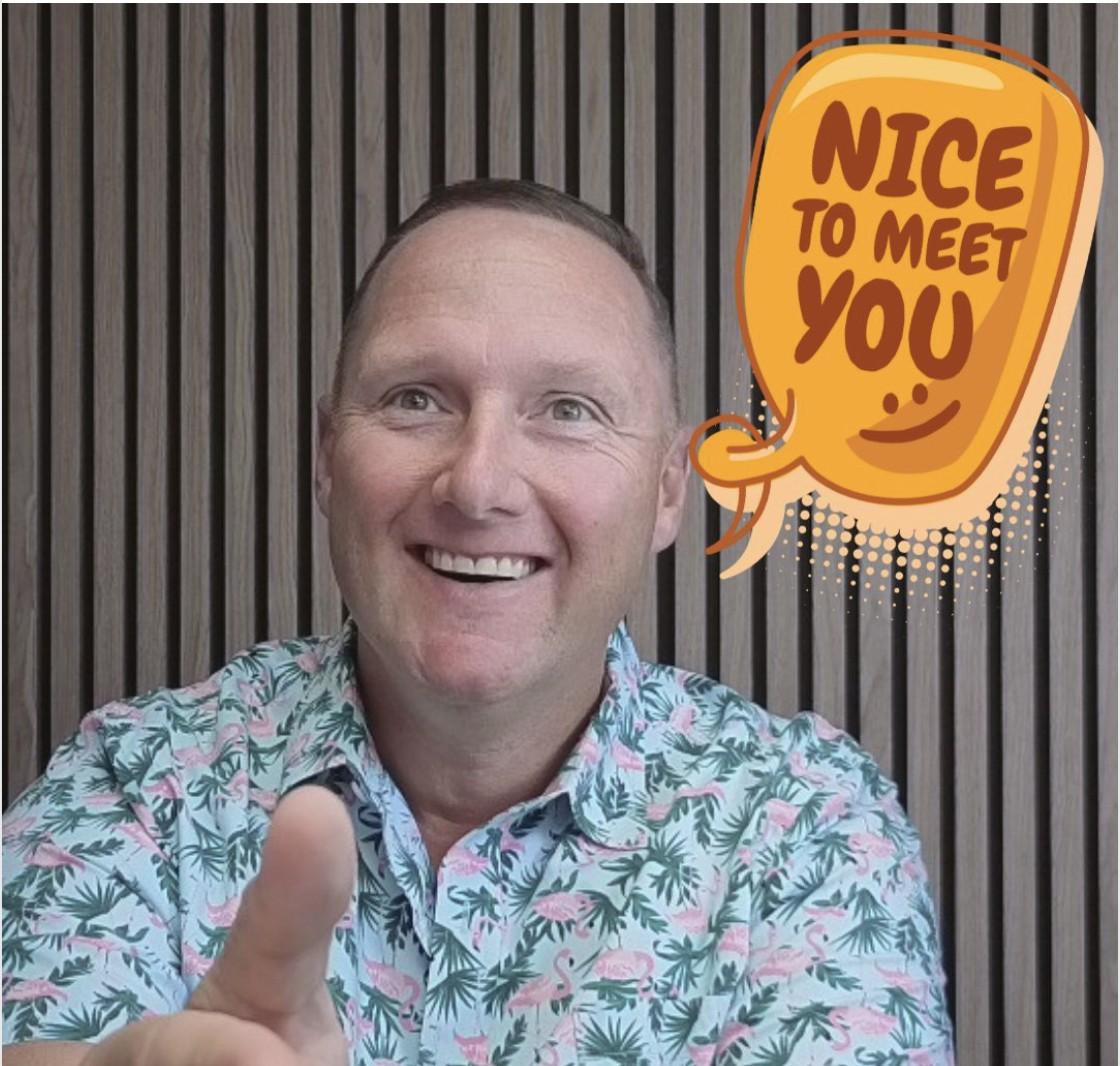 Wayne smiling and pointing at the camera in a floral shirt, with a comic-style speech bubble reading 'Nice to Meet You.'