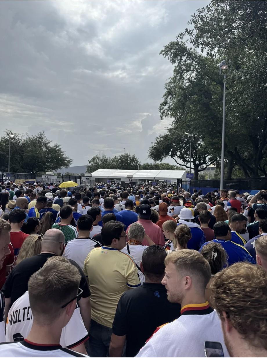A dense crowd of fans queued outside a stadium entrance.